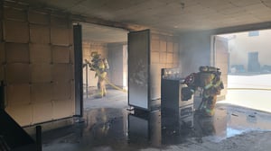 Firefighters training inside a burn room designed to meet NFPA 1400 training facility requirements